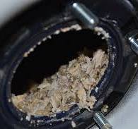 Chunks of calcium sediment clogging a water heater drain opening