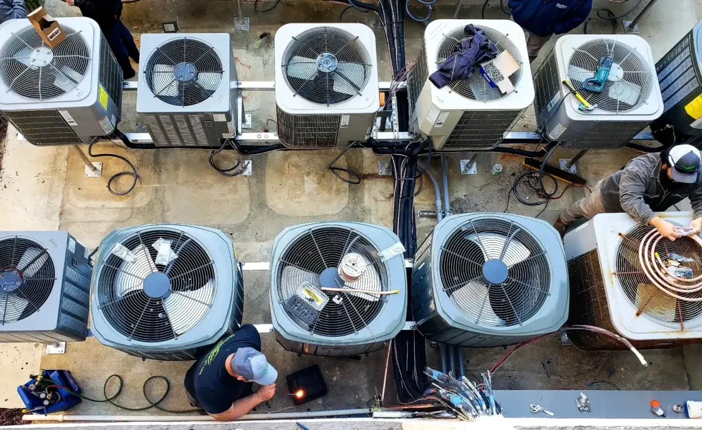 HVAC PROZ technicians servicing an outdoor air conditioning condenser unit